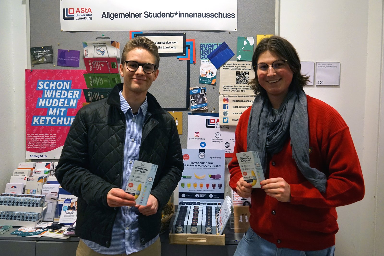 Luis de la Spondoms (stânga) deschide distribuitorul de prezervative gratuite împreună cu Max de la AStA de la Universitatea Leuphana din Lüneburg (dreapta).