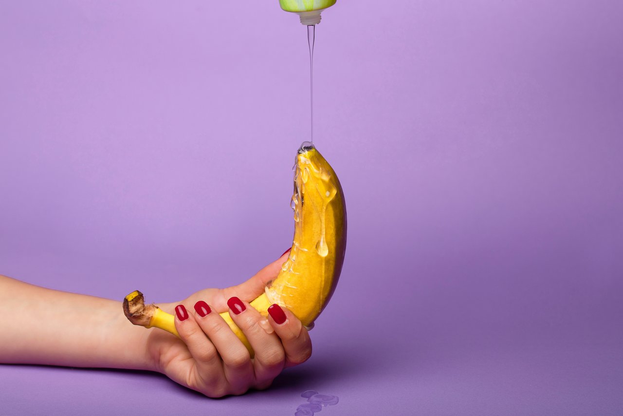 Lubrifiantul se trece peste o banană ținută de o mână